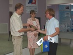 Член Совета, Председатель Алтайского регионального отделения Российского союза молодых ученых Евгений Попов награждает участников выставки